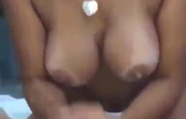 Peituda safada lambuzando a piroca e tocando uma bronha com duas mãos